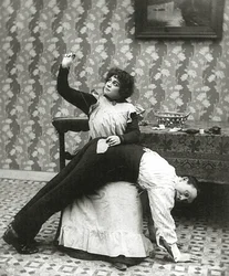 Vrouw die een scheur in een broek van een man naait, c.1895
